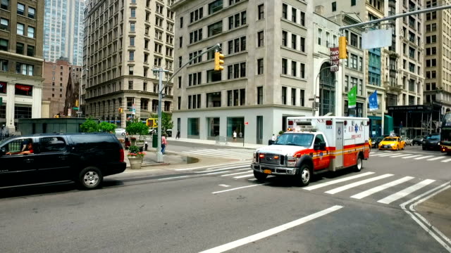 Panning: New York City Fire Department Ambulance rides with siren on.
