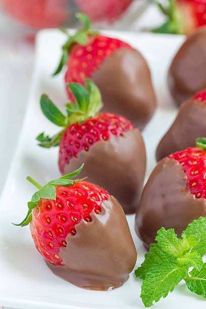 istock Strawberries covered with milk chocolate on a white plate 542795480