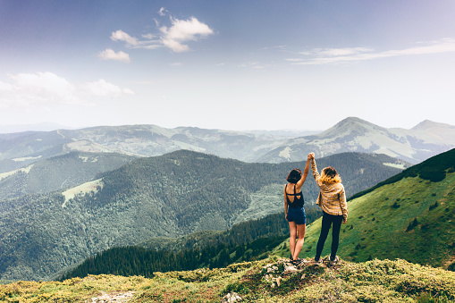 Two girls standing and looking at the view from mountains 