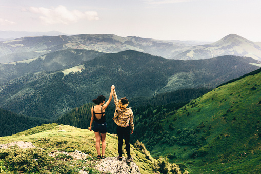 Two girls standing and looking at the view from mountains 
