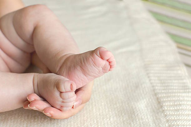 istock Baby foot in mother's hands 542796604