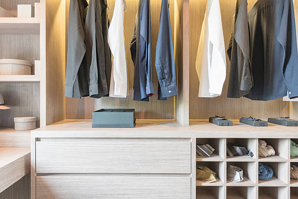istock clothes hanging in wooden walk in closet 542797600