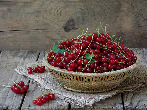 istock Red currants in a basket on a wooden background 542798862