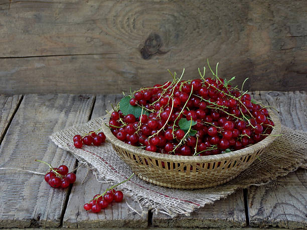 istock Red currants in a basket on a wooden background 542799202