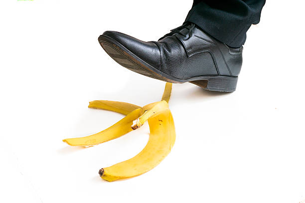 istock Walking businessman is going to slip on banana peel. 542802836
