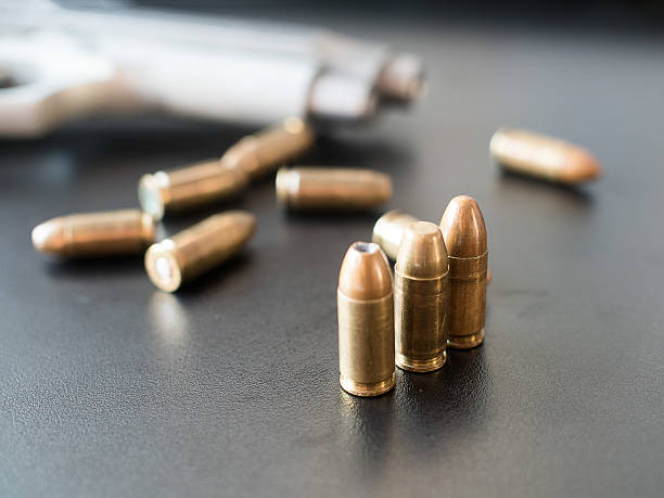 istock 11mm bullets and short gun on black background. (selective focus) 542803732