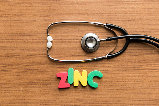 zinc colorful word with stethoscope on wooden background