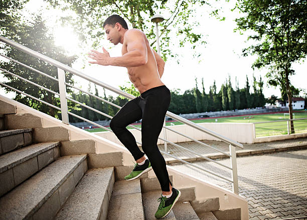 istock athletic sport runner man running up stairs in urban training 542806850