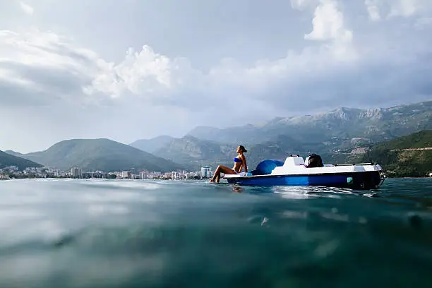 girl sunbathe in sea on paddle boat catamaran with picturesque view