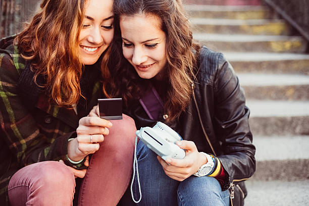 Girls enjoying instant photo Smiling girls making instant photos with instant camera cute id pictures stock pictures, royalty-free photos & images