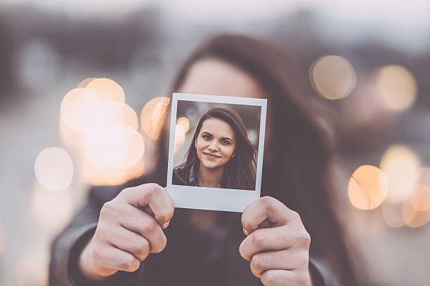 istock Young woman showing instant selfie 542809420