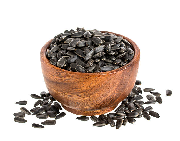 istock Black sunflower seeds in bowl isolated on white background 542809926