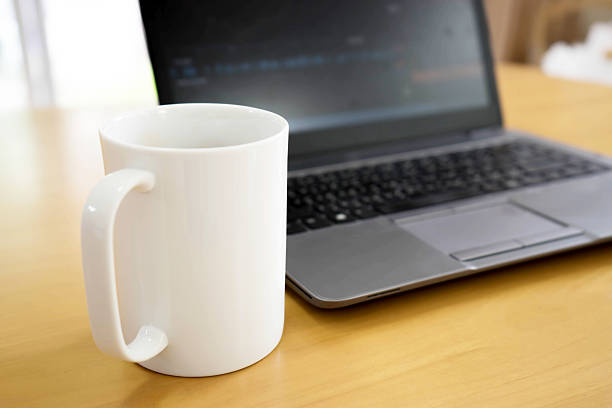 istock Laptop and coffee cup on wood table. View from above 542810100