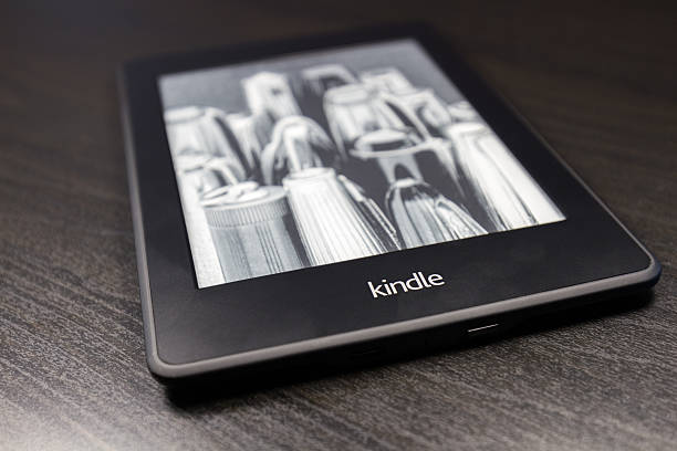 amazon kindle leitor de ebook sobre o preto tabela - kindle e reader book reading imagens e fotografias de stock