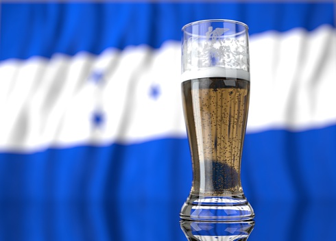 a realistic glass of beer in front a honduran flag. 3D illustration rendering.