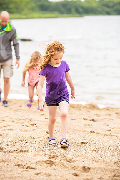 istock Two Girls & Dad Walking on Beach 542816940