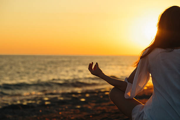 istock Young woman practicing morning yoga in nature at the beach 542819082