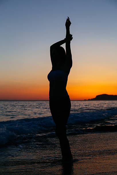istock Sexy slender woman posing against sunset at beach 542821154