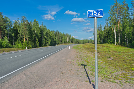 Milepost on the federal highway A121. Sunny day in June. South Karelia, Russia.