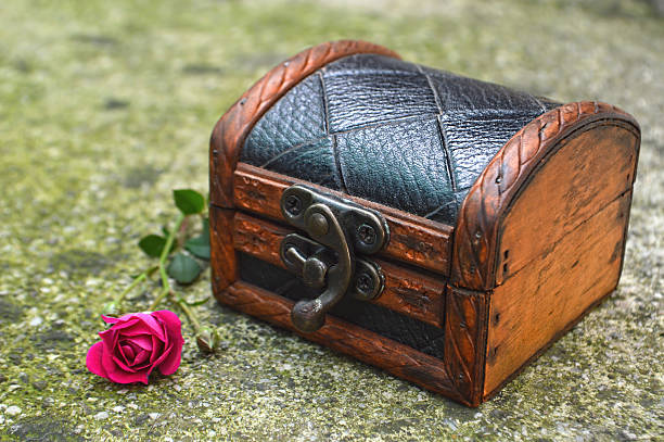 istock Wooden chest and a rose on concrete background 542822878