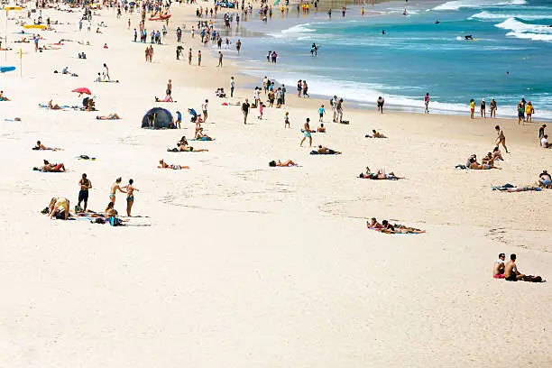 Summer at the beach and ocean, Bondi Beach is crowded with a large number of beachgoers on a hot Sunday afternoon, Sydney Australia, full frame horizontal composition with copy space