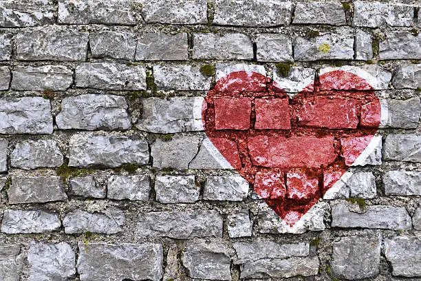 Heart shape painted on stone brickwall