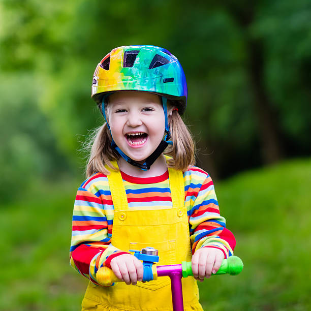 istock Little girl riding a colorful scooter 542824062