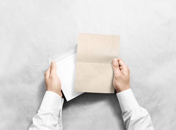 istock Hand holding blank envelope and kraft letter mockup, isolated. 542824326