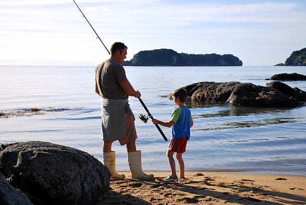 padre e figlio pesca d'altura - golden bay foto e immagini stock
