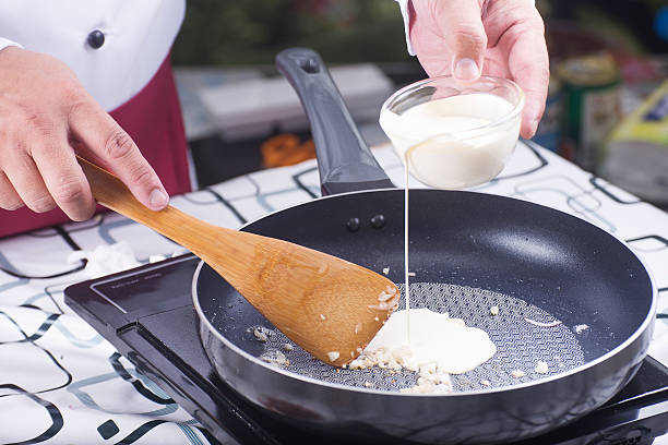 istock Chef pouring Whipping cream to the pan 542825658