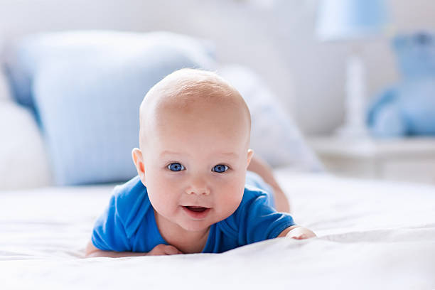 istock Baby boy relaxing in white sunny bedroom 542827000
