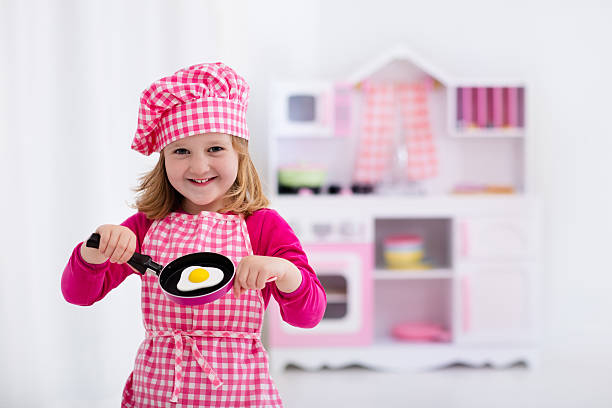 istock Little girl playing with toy kitchen cooking fried eggs 542827660