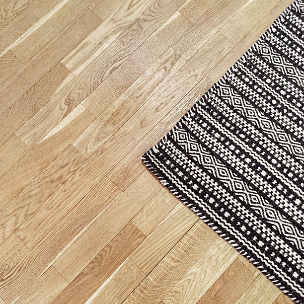 Stylish black and white rug on wooden floor
