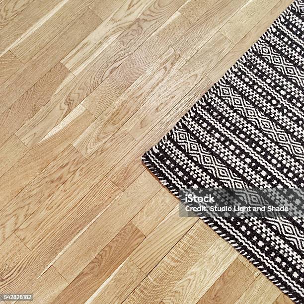 Stylish Black And White Rug On Wooden Floor Stock Photo - Download Image Now - Rug, Corner, Flooring