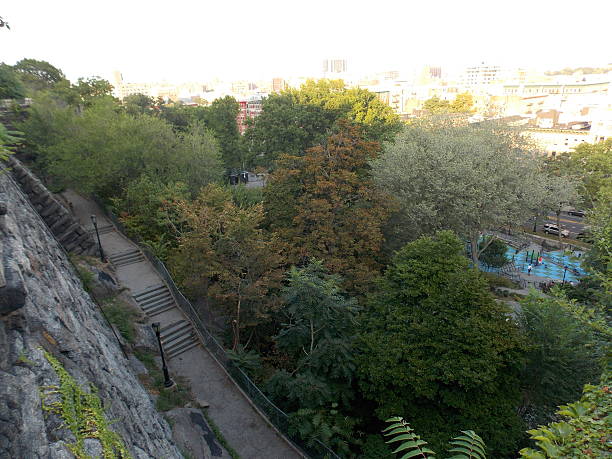 Aerial View of Morningside Park in New York City A view of the many steps and trees, as well as a peek at a children's playground, in Morningside Park from the west edge of the park looking down. City buildings can barely be seen beyond the trees. harlem park stock pictures, royalty-free photos & images