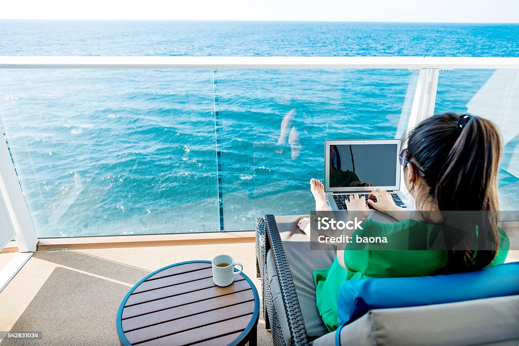 Woman working on cruise ship Woman working with a laptop on cruise ship. Cruise Ship Stock Photo