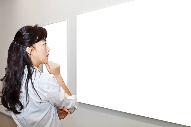 istock One woman looking at white frames in an art gallery 542831456