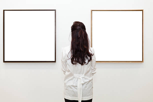 istock One woman looking at white frames in an art gallery 542831514