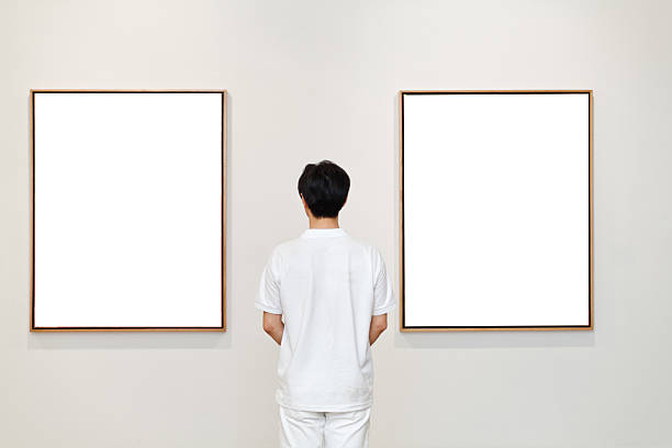 istock One man looking at white frames in an art gallery 542831526