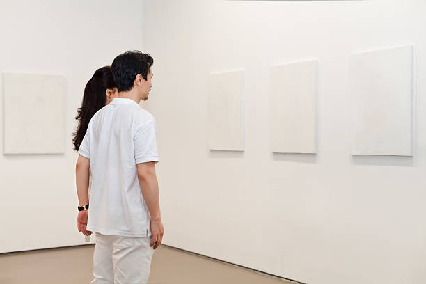 istock Two people looking at white frames in an art gallery 542831536