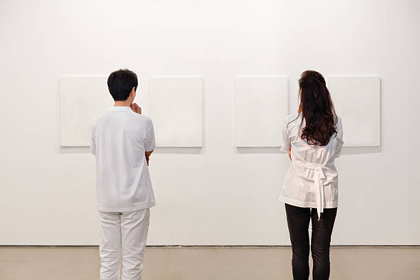 istock Two people looking at white frames in an art gallery 542831558