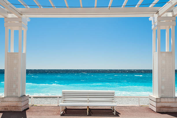 White benches on the Promenade des Anglais in Nice, France White benches on the Promenade des Anglais in Nice, France. Beautiful turquoise sea and beach nice france stock pictures, royalty-free photos & images