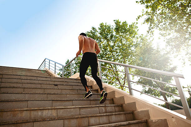 istock athletic sport runner man running up stairs in urban training 542836156