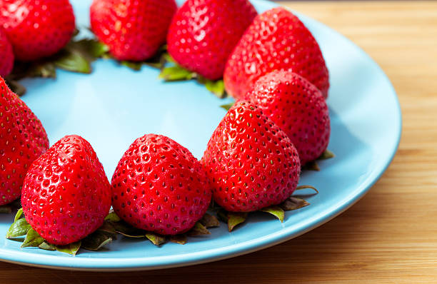 Ripe red strawberries on blue plate