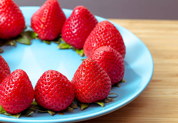 Ripe red strawberries on blue plate