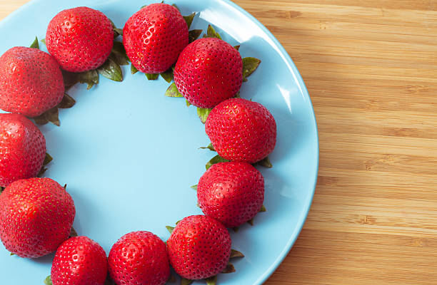 Ripe red strawberries on blue plate