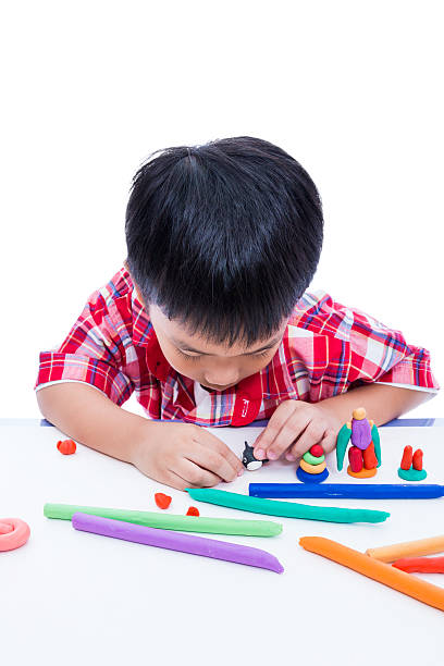 istock Child moulding whale modeling clay, on white background. Strengt 542926998
