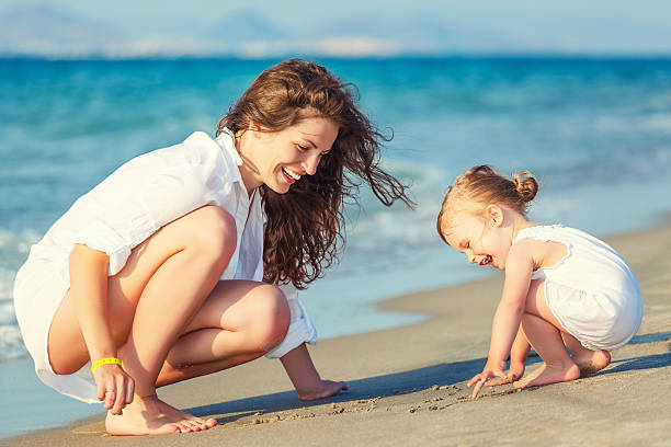 istock Mother and daughter playing on the beach 542931916