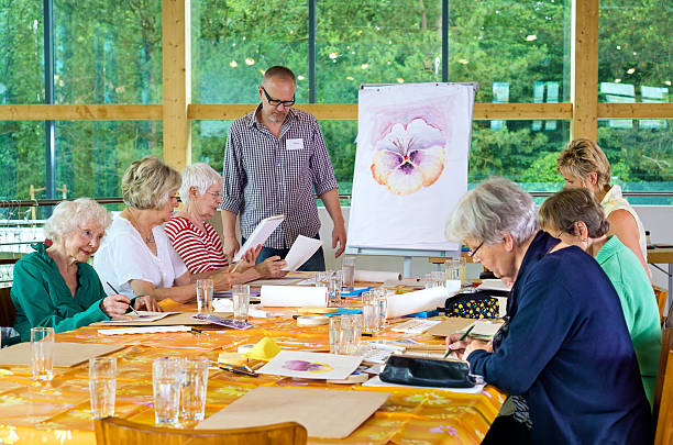 istock Teacher with group of students in painting class. 542932594