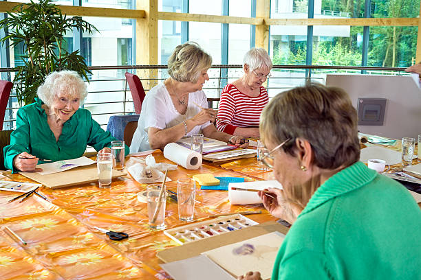Grupo de alegres estudiantes mayores pintando juntos. - foto de stock